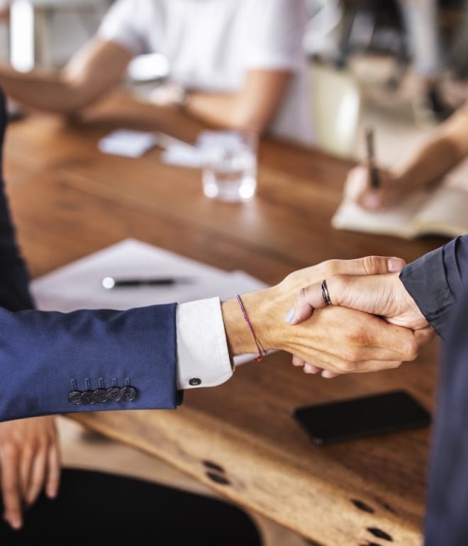 business handshake in office VYYYLWL e1650789239773