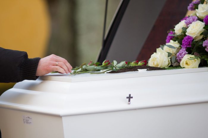 closeup shot of a person hand on a casket